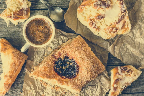 Завтрак с откормом - французская выпечка, сладкая булочка и чашка кофе на деревянном столе, плоские накладные расходы — стоковое фото