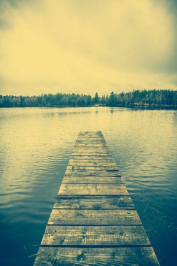 Sonbahar manzarası, göl romantik ahşap iskele veya üzerinde sakin su yüzeyi, vintage fotoğraf ahşap iskelesi ile
