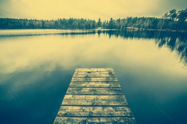 Sonbahar manzarası, göl romantik ahşap iskele veya üzerinde sakin su yüzeyi, vintage fotoğraf ahşap iskelesi ile