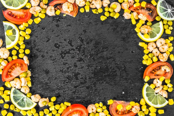 Cornice colorata con verdure, frutta al limone e gamberi della cucina mediterranea su sfondo nero — Foto Stock