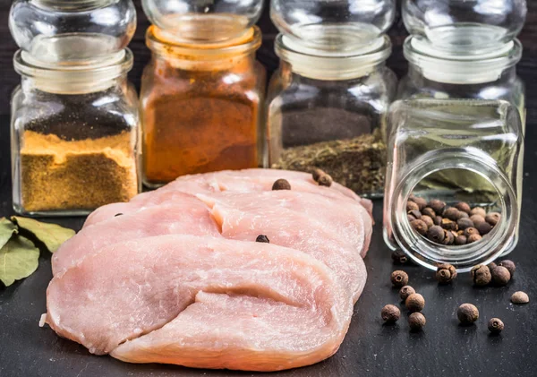 Raw turkey breast slices with spices on table. — Stock Photo, Image