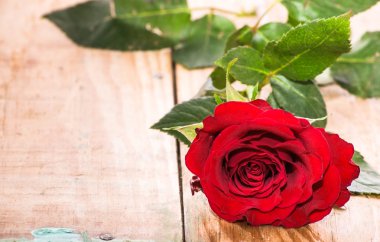 Ahşap zemin, düğün davetiyesi üzerine kırmızı gül