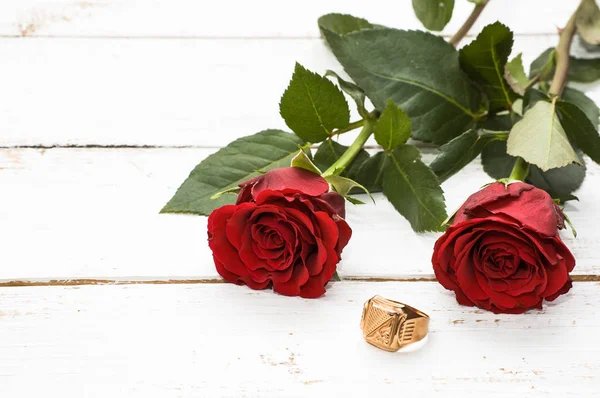 Pierścionek zaręczynowy i czerwone róże na podłoże drewniane, zaproszenie ślubne — Zdjęcie stockowe