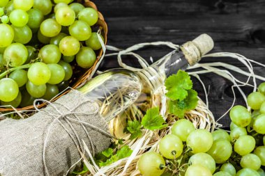 Yeşil üzüm gelen beyaz şarap şişesi. Yaşlı ahşap kiler içinde ev yapımı şarap.