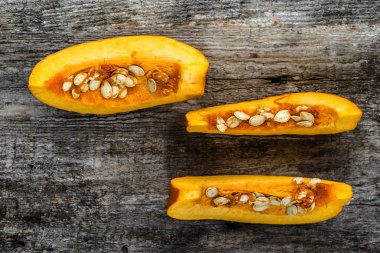 Yukarıdan, dilimleri ile tohum kabak düz lay ahşap arka plan üzerine dilimlenmiş