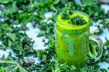 Yeşil sebze lahana yapraklarının ile güler yüzlü, ahşap arka plan üzerinde içki Detoks