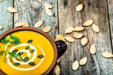 Maydanoz ve tohumlar üzerinde ahşap masa, vejetaryen tabağı ile kabak çorbası