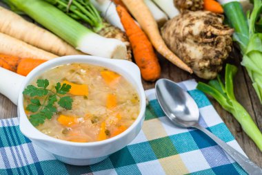 Bir kase ve ahşap masa üzerinde taze sebze sebze çorbası