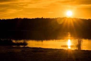 Turuncu günbatımı göl ve orman üzerinde siluet, manzara sonbahar, Polonya