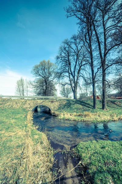 Puente de piedra sobre el río, paisaje de primavera temprana —  Fotos de Stock