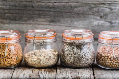 Sağlıklı vegan gıda, tohum ve tahıl rustik masa, nohut, bezelye, ayçiçeği tohumu, yulaf ezmesi olarak kavanozlara