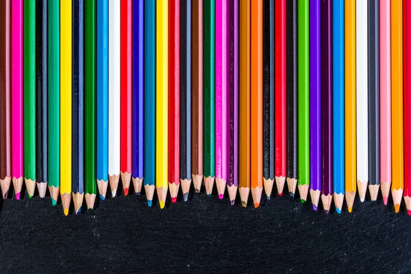 Colored pencils background, border on black, copy space — Stock Photo, Image