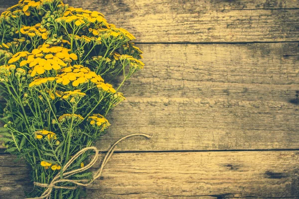 Yellow flowers from summer meadow, rustic bouquet located on wooden background — Stock Photo, Image