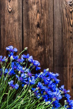 Ahşap arka plan üzerinde seçili mavi çiçekli çerçeve çiçek