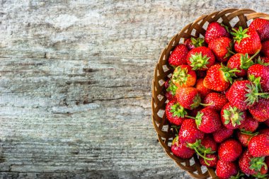 Taze çilek sepeti, çiftçi pazarda, ahşap masa, olgunlaşmış meyve alanı Kopyala