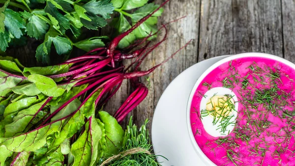 Sopa de beterraba fria e legumes verdes na mesa de madeira, conceito de culinária de verão — Fotografia de Stock