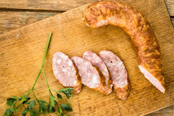 Salsicha defumada de carne de porco no fundo de madeira — Fotografia de Stock