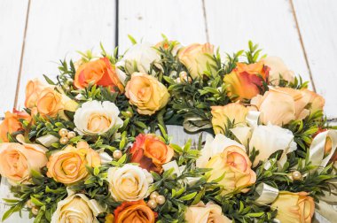 Beyaz ahşap zemin üzerinde Güllü düğün çelengi