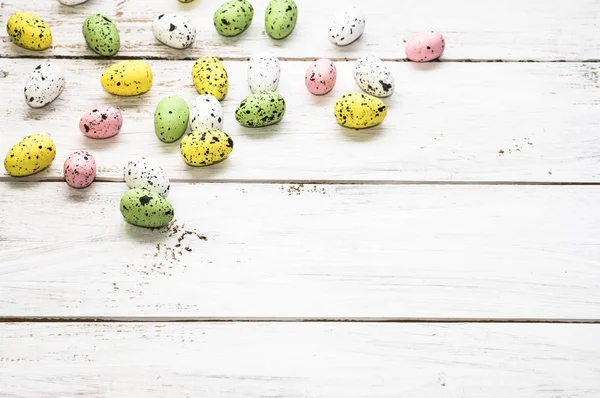 Fondo de Pascua con coloridos huevos de Pascua en tablas de madera blanca — Foto de Stock
