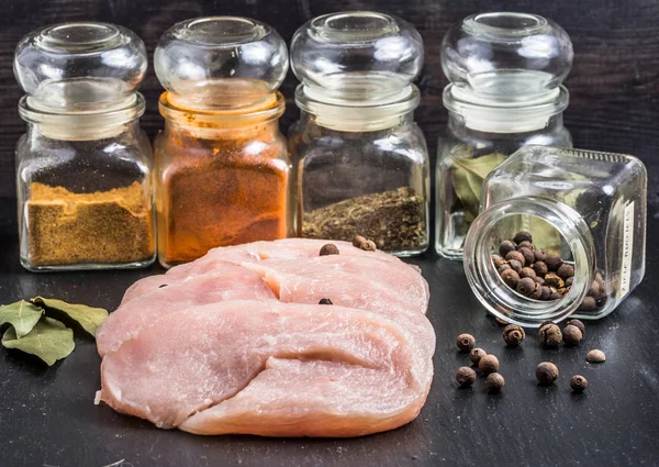 Rohe Putenbrustscheiben mit Gewürzen auf dem Tisch. — Stockfoto