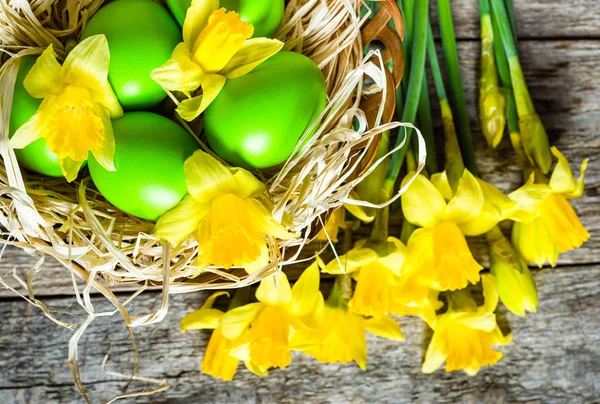 Fond de Pâques de printemps avec jonquilles et oeufs de Pâques dans le panier — Photo