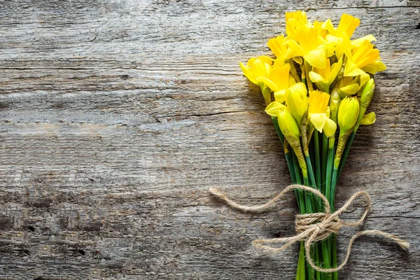 Fondo de Pascua de primavera con ramo de narcisos en la mesa de madera — Foto de Stock