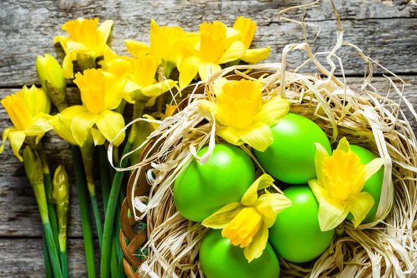 Fundo de Páscoa com narcisos e ovos de Páscoa na cesta — Fotografia de Stock