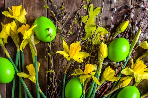 Table avec oeufs de Pâques et jonquilles, fond de printemps — Photo