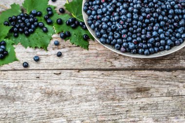 Ahşap masa, ormandaki çiftçi piyasasında olgunlaşmış meyve sepeti taze yaban mersini alanı, üstten görünüm Kopyala