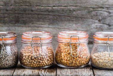 Sağlıklı vegan gıda, tohum ve tahıl rustik masa, nohut, bezelye, ayçiçeği tohumu, yulaf ezmesi olarak kavanozlara