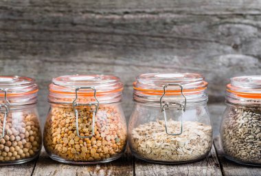 Sağlıklı vegan gıda, tohum ve tahıl rustik masa, nohut, bezelye, ayçiçeği tohumu, yulaf ezmesi olarak kavanozlara