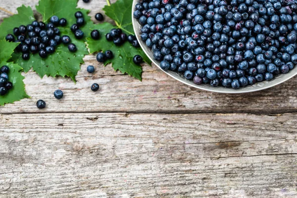 Ahşap masa, ormandaki çiftçi piyasasında olgunlaşmış meyve sepeti taze yaban mersini alanı, üstten görünüm Kopyala