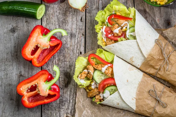 Deliziosi involucri di tortilla, panini burritos ripieni di carne di pollo e verdure, fast food della cucina messicana — Foto Stock