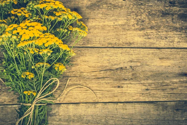 Yellow flowers from summer meadow, rustic bouquet located on wooden background — Stock Photo, Image