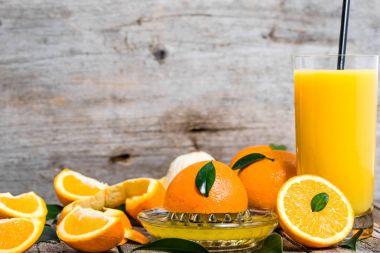 Bardak portakal suyu ve taze turuncu meyveler rustik ahşap tablo