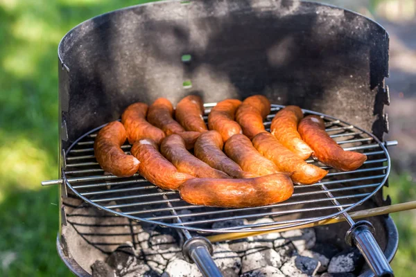 Barbecue-grill z pieczeniem kiełbasek, weekend party na zewnątrz — Zdjęcie stockowe