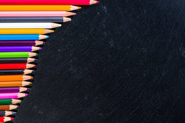 Цветные карандаши фон, рамка на черном, копировальное пространство, вернуться к школьной концепции — стоковое фото