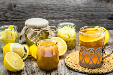 Ahşap arka plan üzerinde limonlu çay. Malzemeler bir cam kavanoz, zencefil ve bal.