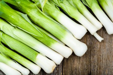 Taze pırasa, yeşil sebzeler, ahşap rustik masada çiftlik taze ürün görünümü top