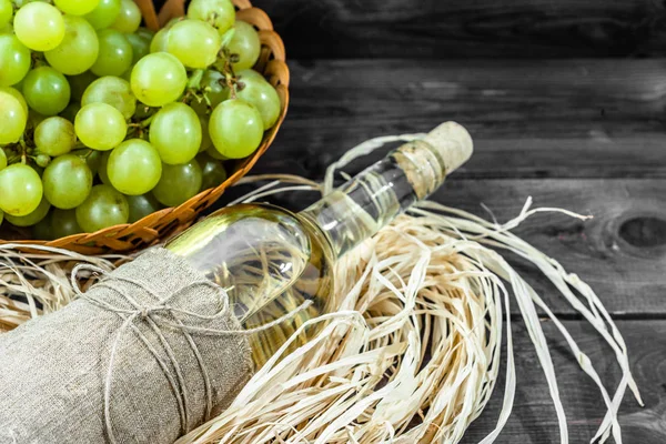 Yeşil üzüm gelen beyaz şarap şişesi. Yaşlı ahşap kiler içinde ev yapımı şarap.