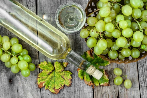 Garrafa de vinho branco e copos de vinho de uva verde. Vinho caseiro sazonal em despensa de madeira . — Fotografia de Stock