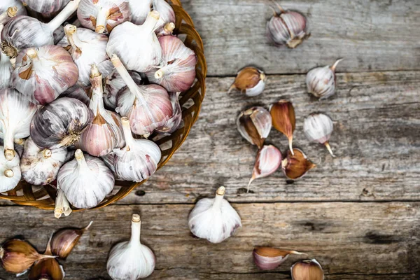 stock image Fresh garlic in the basket, top view. Farm vegetables on wooden table.