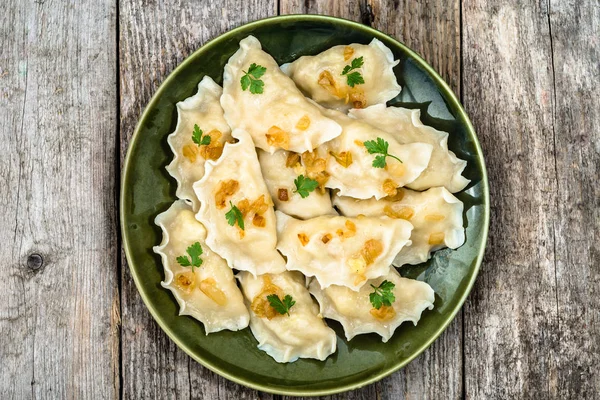 Zelfgemaakte dumplings met gebakken UI op plaat, bovenaanzicht, koken concept — Stockfoto