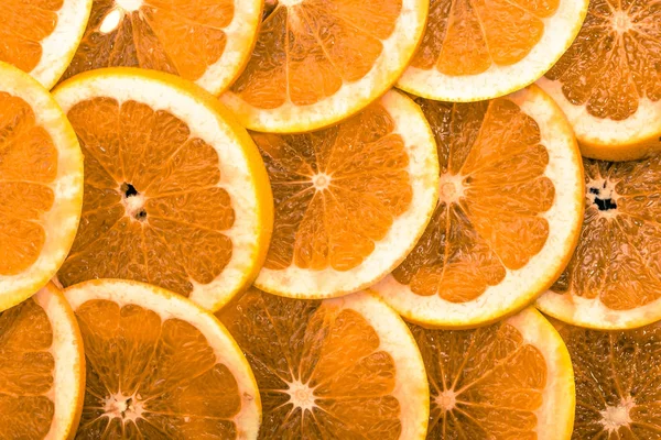 Textuur van oranje fruit plakjes, close-up, overhead, citrus achtergrond — Stockfoto