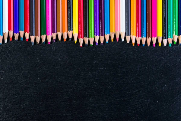 Fondo colorido de los útiles escolares, lápices de colores en negro, concepto de vuelta a la escuela —  Fotos de Stock