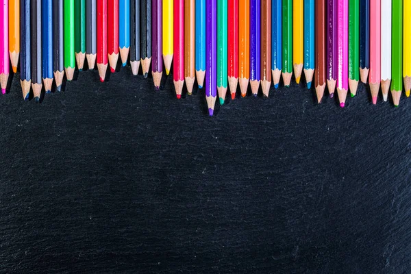 Fondo colorido de los útiles escolares, lápices de colores en negro, concepto de vuelta a la escuela —  Fotos de Stock