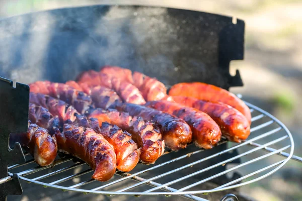 Grilled sausage on barbecue grill, picnic outdoors — Stock Photo, Image