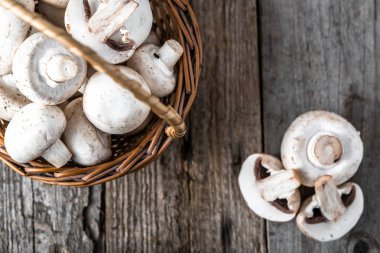 Ahşap masa, ek yükü bir sepet içinde taze champignon mantar