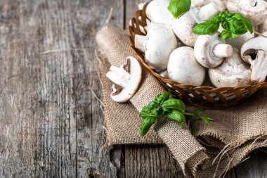 Ahşap masa, ek yükü bir sepet içinde taze champignon mantar