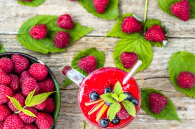 Ahududu güler yüzlü bir cam kavanoza iç çilek, sulu meyve mus, doğal detoks